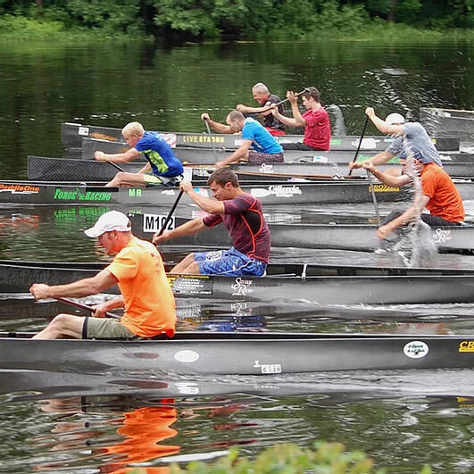 people paddling in canoes