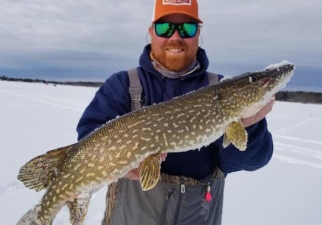 ice fisherman holding fish