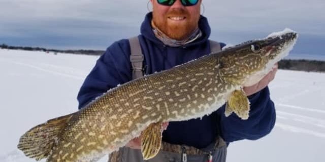 ice fisherman holding fish