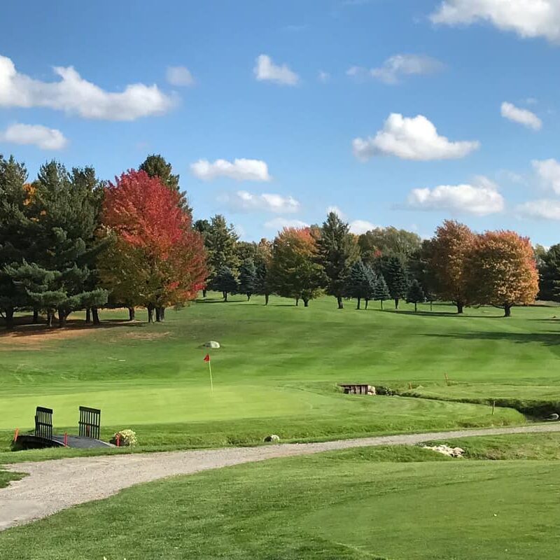 golf course on a sunny day with fall leaves on the trees